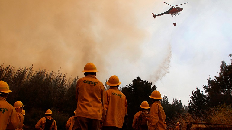A helicopter dumps water during a forest fire in the town of Empedrado in the Maule region, south of Chile January 23, 2017. REUTERS/Cristobal Hernandez FOR EDITORIAL USE ONLY. NO RESALES. NO ARCHIVE.